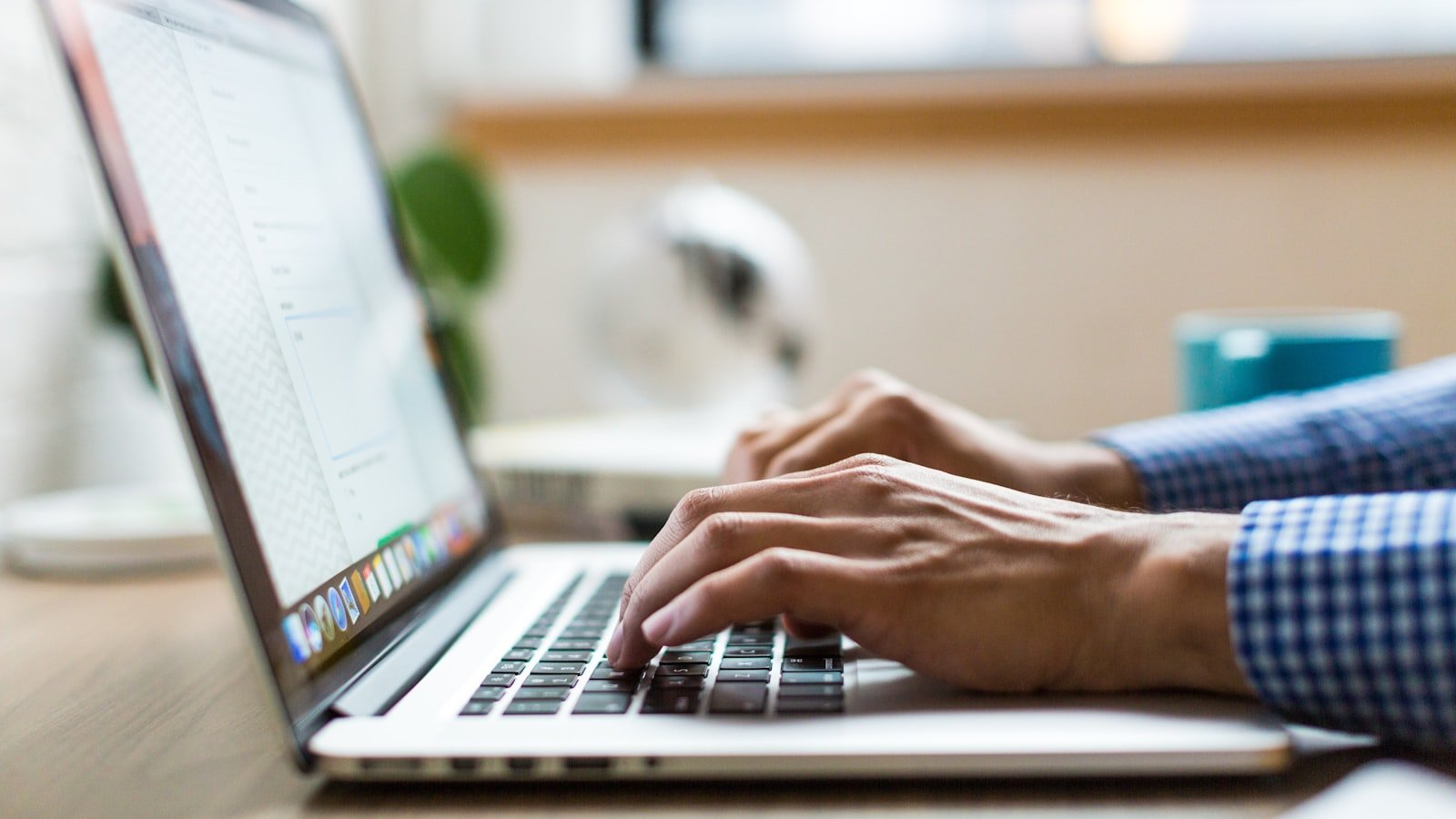 A person typing on a laptop while editing on-page SEO elements like title tags and meta descriptions on a small business website