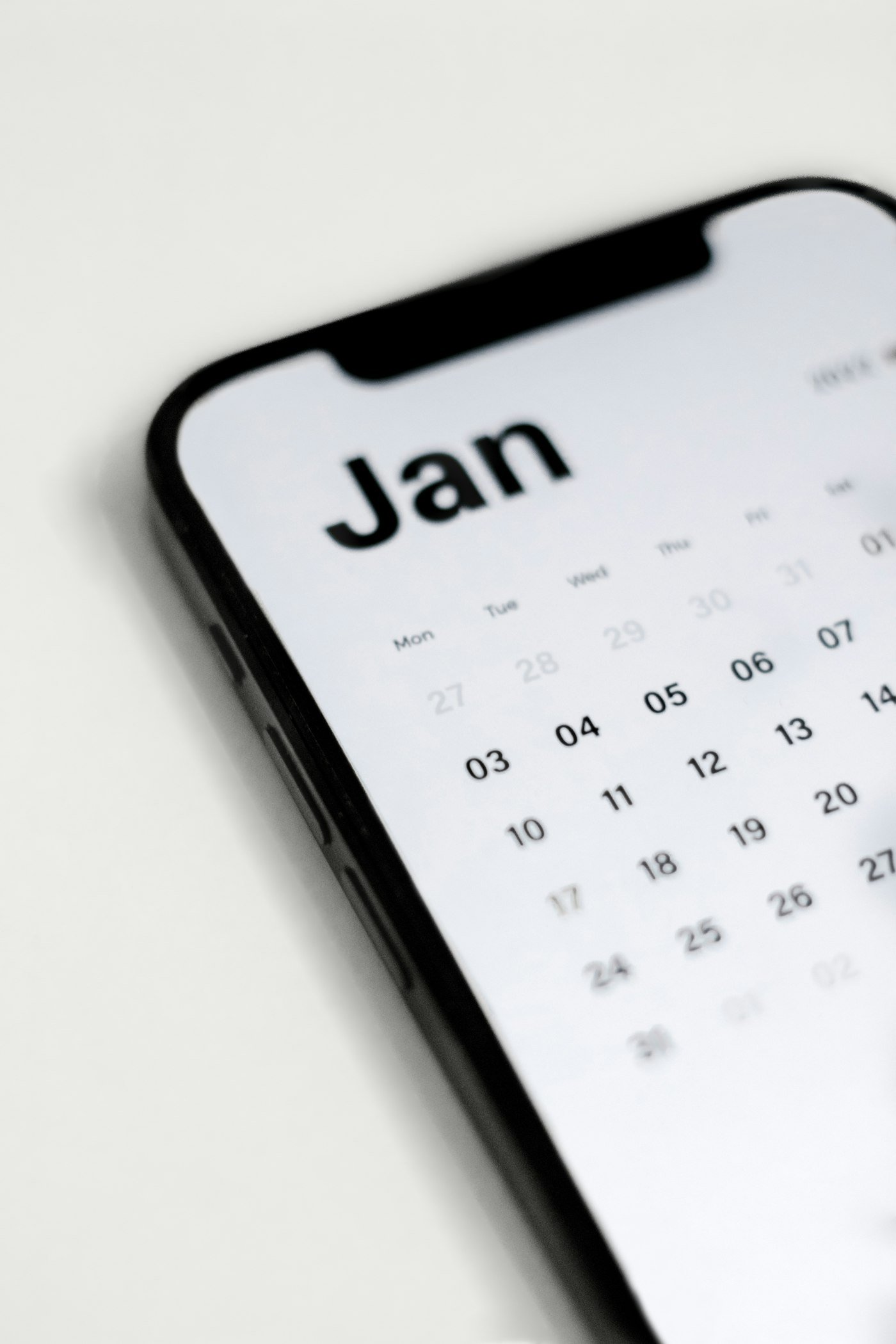 Close-up of a smartphone screen displaying a calendar app used to book an appointment on the go